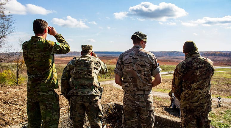 Four Soldiers Standing In A Field